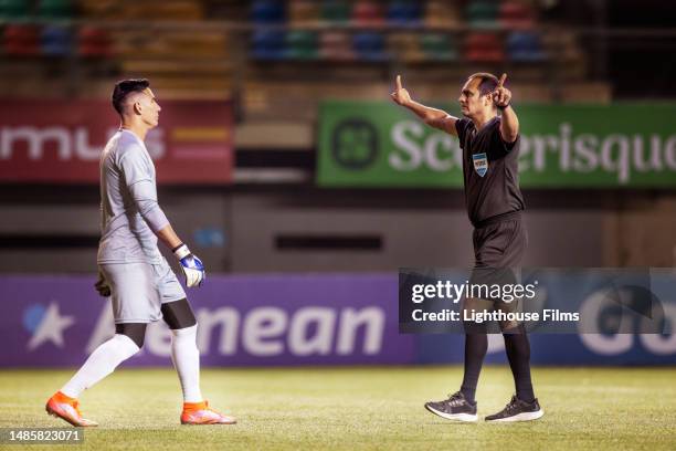 professional soccer referee orders goalie to back up before a penalty kick is performed - defence technology stock pictures, royalty-free photos & images