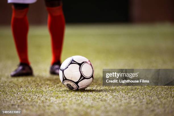 professional soccer player prepares to strike soccer ball with his cleat on stadium field - futebol-de-clubes imagens e fotografias de stock