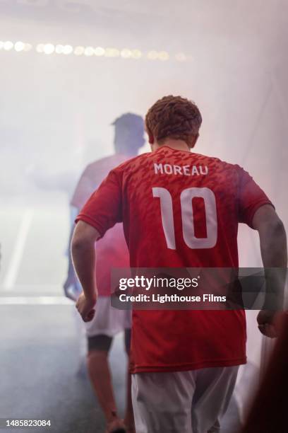 professional soccer players walk through a tunnel filled with dramatic fog as they enter a championship game - football player tunnel stock pictures, royalty-free photos & images