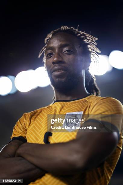 portrait of an adult soccer player looking at the camera with his arms crossed before a championship game - guy with attitude mid shot stock-fotos und bilder