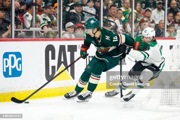 Matt Boldy of the Minnesota Wild skates with the puck past Thomas Harley of the Dallas Stars in the first period of Game Four of the First Round of...