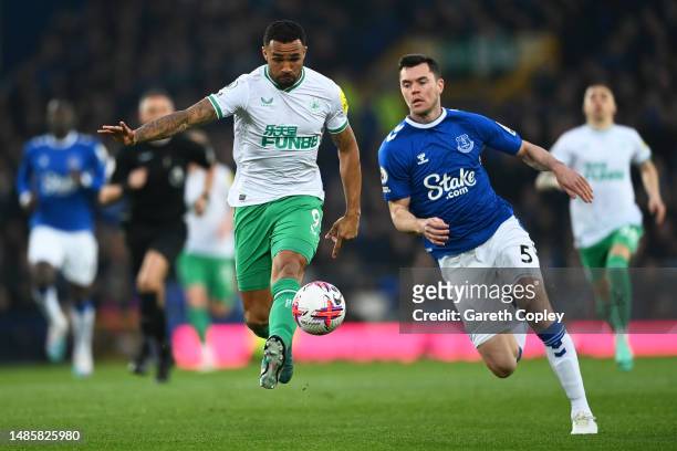 Callum Wilson of Newcastle United runs with the ball whilst under pressure from Michael Keane of Everton during the Premier League match between...