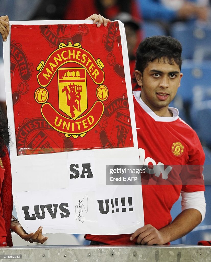 A Manchester United fan displays a banne