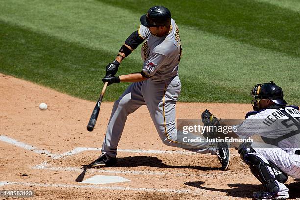 Garrett Jones of the Pittsburgh Pirates hits a three-run home run during the third inning as catcher Ramon Hernandez of the Colorado Rockies looks on...