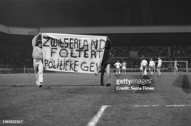 Political demonstration against Switzerland. Banner reads, Switzerland tortures political prisoners, March 28 protesters, banners, sports, soccer.