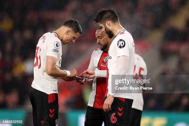 Duje Caleta-Car, Jan Bednarek and Theo Walcott of Southampton look at a piece of paper during the Premier League match between Southampton FC and AFC...