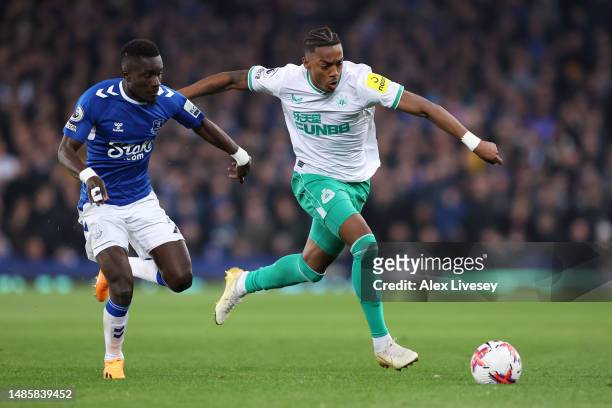 Joe Willock of Newcastle United runs with the ball whilst under pressure from Idrissa Gueye of Everton during the Premier League match between...