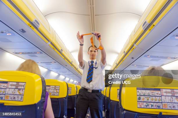 Flight attendant doing the take off safety demonstration on board Ryanair plane, UK.