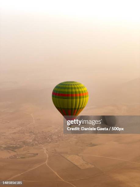 aerial view of hot air balloon flying over landscape - hot air ballon foto e immagini stock