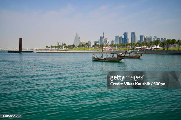 scenic view of sea and buildings against sky,doha,qatar - doha qatar stock pictures, royalty-free photos & images