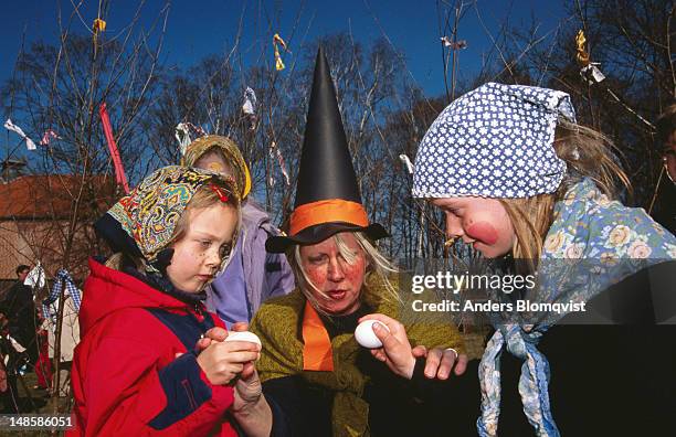 children dressed up as easter witches with eggs at fredriksdal open air museum. - heks stockfoto's en -beelden