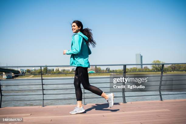 jeune femme en bonne santé qui fait de l’exercice à l’extérieur - joggeuse photos et images de collection