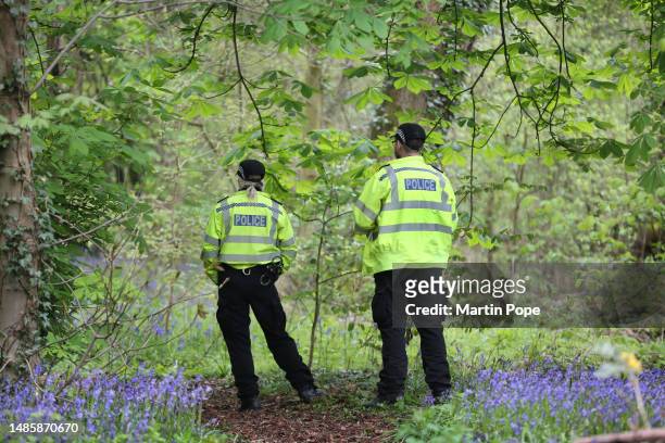 Police officers keep a look out for activists in the woodland adjacent to UAV tactical Systems ahead of the threatened siege on April 27, 2023 in...