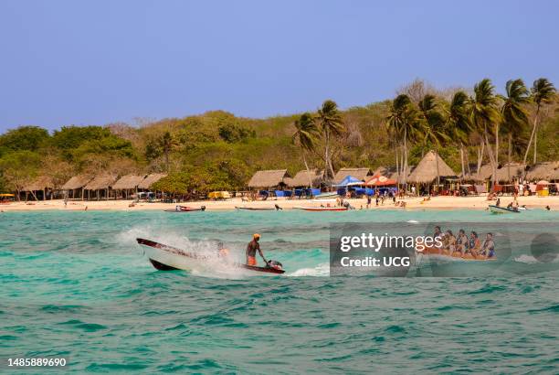 Tourists having fun at Playa Blanca on the Isla de Baru along the coast from Cartagena de Indias, Colombia.