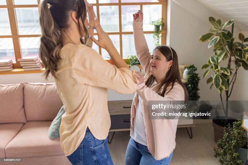 Female friends dancing at home