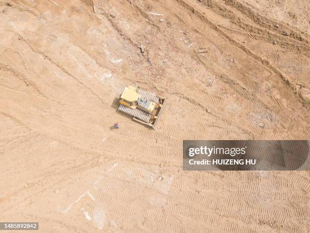 aerial view of a bulldozer leveling the ground on a construction site - bulldozer stock pictures, royalty-free photos & images