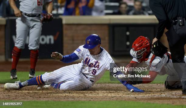Brandon Nimmo of the New York Mets scores on a sixth inning double from teammate Francisco Lindor as Keibert Ruiz of the Washington Nationals can't...