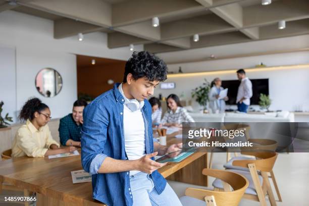 junger geschäftsmann, der mit einem tablet-computer im büro arbeitet - internship marketing stock-fotos und bilder