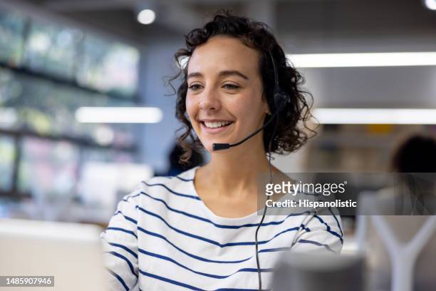 customer service representative using a headset while working at a call center - financial advisor phone stock pictures, royalty-free photos & images