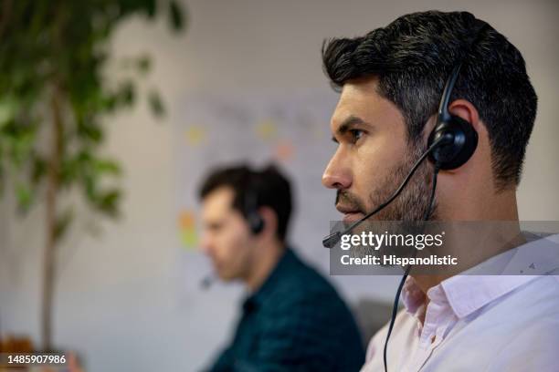 man working as customer service representative at a call center - customer retention stock pictures, royalty-free photos & images