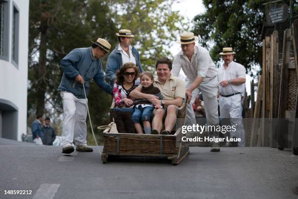 people in basket sled on monte toboggan run. - funchal stock pictures, royalty-free photos & images