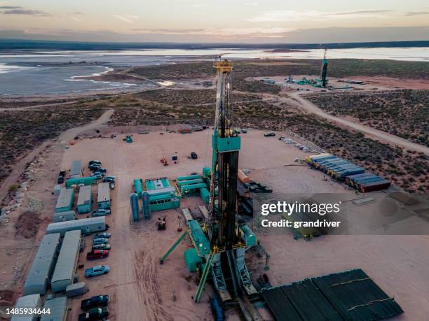 drone captures a breathtaking sunset over the permian basin, showcasing an oil rig drilling and fracking for oil, amidst the vastness of the landscape - borehole stock pictures, royalty-free photos & images