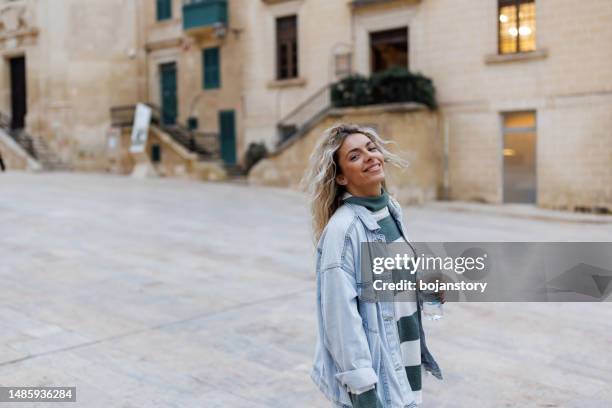 beautiful young woman walking in old mediterranean town - modern malta stock pictures, royalty-free photos & images
