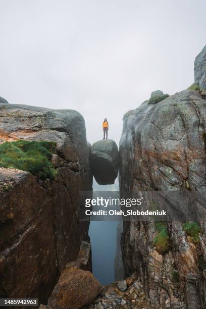 woman standing on kjeragbolten - adrenaline park stock pictures, royalty-free photos & images