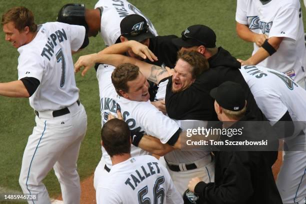 Gregg Zaun of the Toronto Blue Jays is congratulated by Brad Wilkerson and Roy Halladay after hitting a game-winning grand slam home run in the...