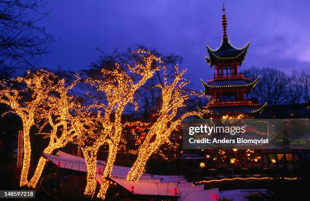 the chinese pagoda with annual christmas market lights in tivoli gardens. - copenhagen christmas market stock pictures, royalty-free photos & images