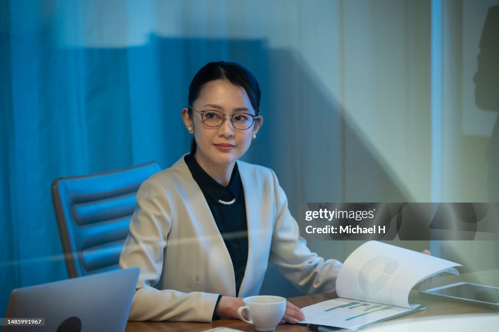 Businesswoman attending a meeting while using a laptop