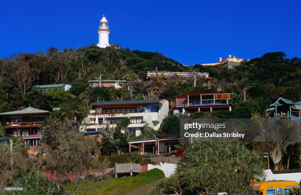 Cape Byron Lighthouse above Wategos Beach houses.