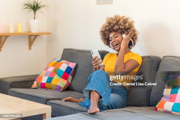 caribbean woman enjoying while listening music with headphones - auriculares stock pictures, royalty-free photos & images