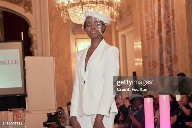 Model wearing a Maison Mira Belle's hat walks the runway during “Montmartre Celebre La Femme” Fashion Shows at Mairie du 18eme on April 27, 2023 in...