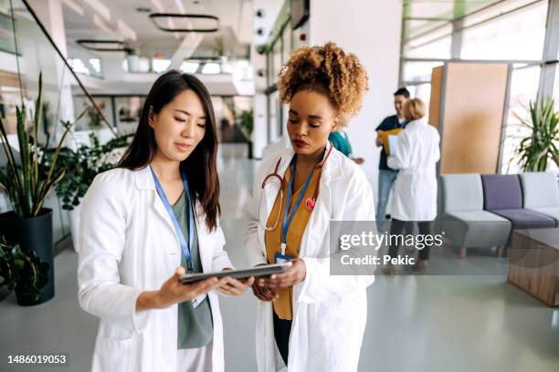 dottoresse che parlano nel corridoio dell'ospedale - infermiere professionista foto e immagini stock