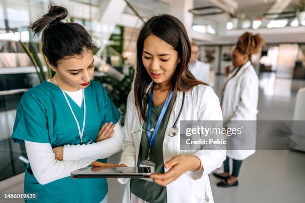 dottoresse che parlano nel corridoio dell'ospedale - infermiere professionista foto e immagini stock