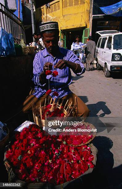 rose petal sellers congregate outside the shrine of muslin sufi saint nizam-ud-din. - national capital territory of delhi stock pictures, royalty-free photos & images