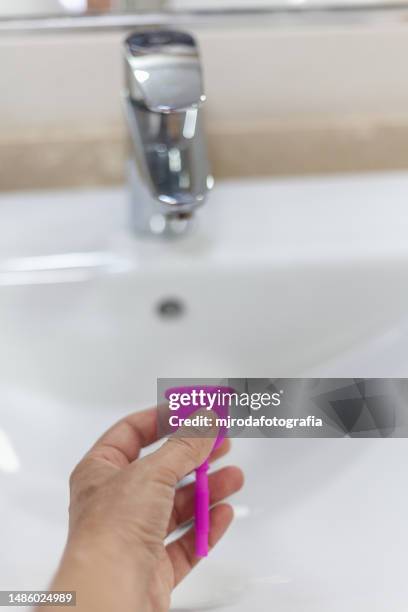 washing the menstrual cup in the bathroom - menstrual cup stock pictures, royalty-free photos & images