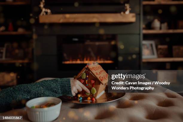 gingerbread house decorating by the fireplace - arizona christmas stock-fotos und bilder