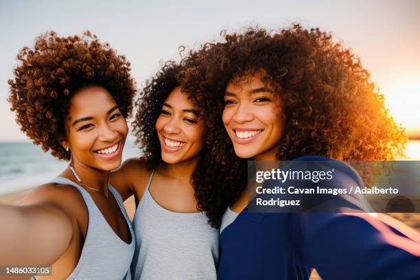 female friends with afro hair take selfie at sunset - curly hair girl photos et images de collection
