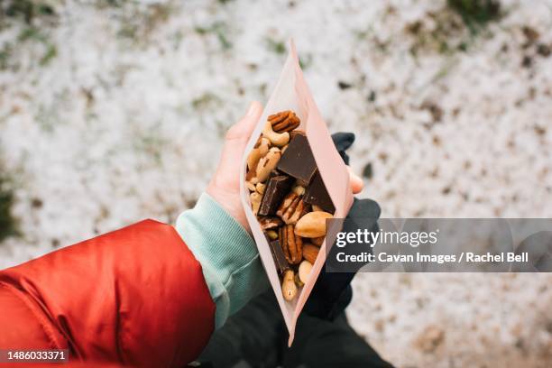 woman holding trail mix in a reusable snack bag whilst hiking - cacahuete alimento fotografías e imágenes de stock