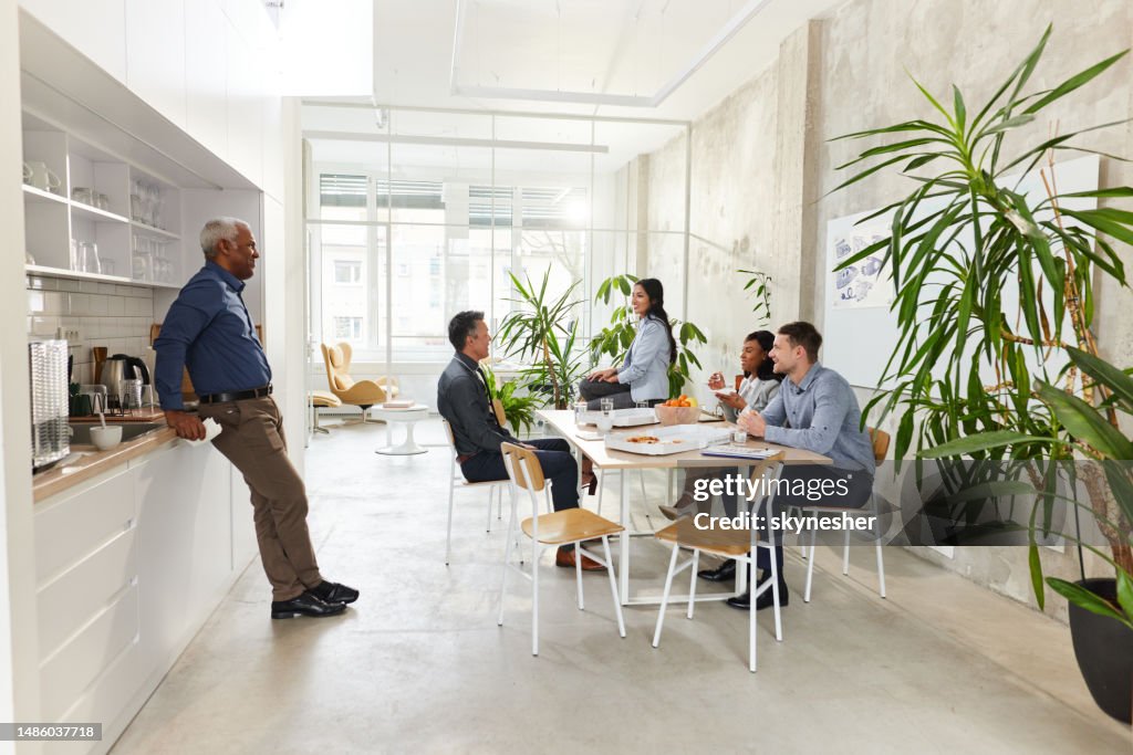 Glückliche Geschäftskollegen unterhalten sich in einer Pause in der Kantine.