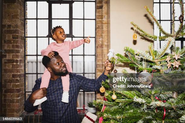 padre e giovane figlia che ammirano le decorazioni dell'albero di natale - front flash photography foto e immagini stock