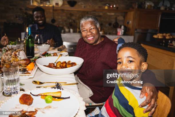 cheerful boy and grandmother at christmas lunch - flash stock pictures, royalty-free photos & images