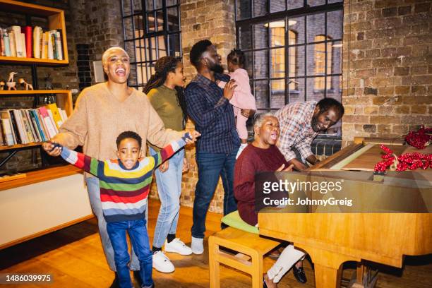festive black family enjoying holiday sing-along - pianist stock pictures, royalty-free photos & images