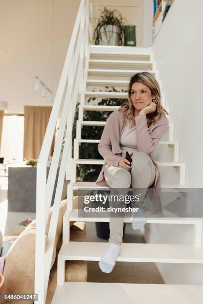 mujer joven soñando despierta en las escaleras de su casa. - woman day dreaming fotografías e imágenes de stock