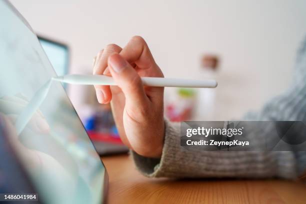 close up to the woman's hand who draws on a digital tablet with a stylus - tablet close up real copyspace stock pictures, royalty-free photos & images