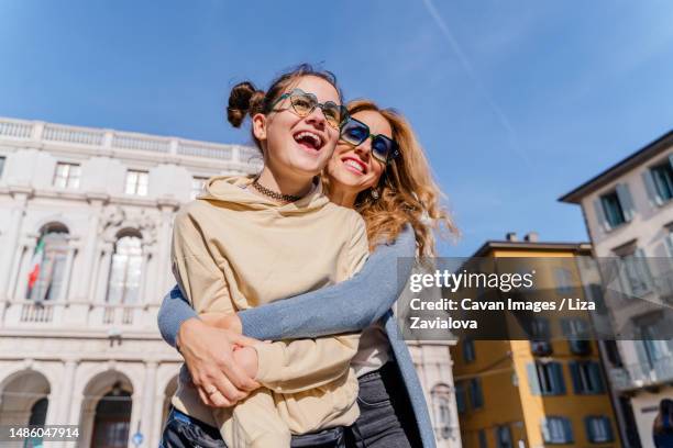 a blond woman and a teenage daughter are walking in an old town - summer cardigan women stockfoto's en -beelden