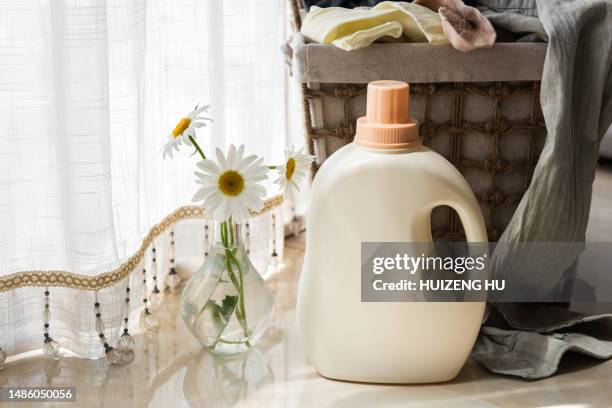 laundry basket with dirty clothes and detergent on floor in room, eco-friendly laundry concept - laundry detergent stock pictures, royalty-free photos & images