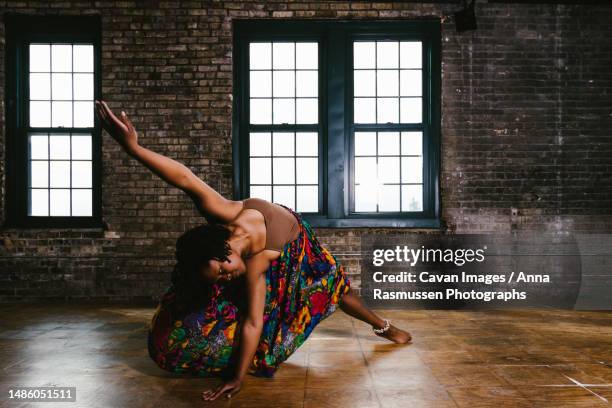 dancer does dancing movement inside building with exposed brick - contemporary dance foto e immagini stock